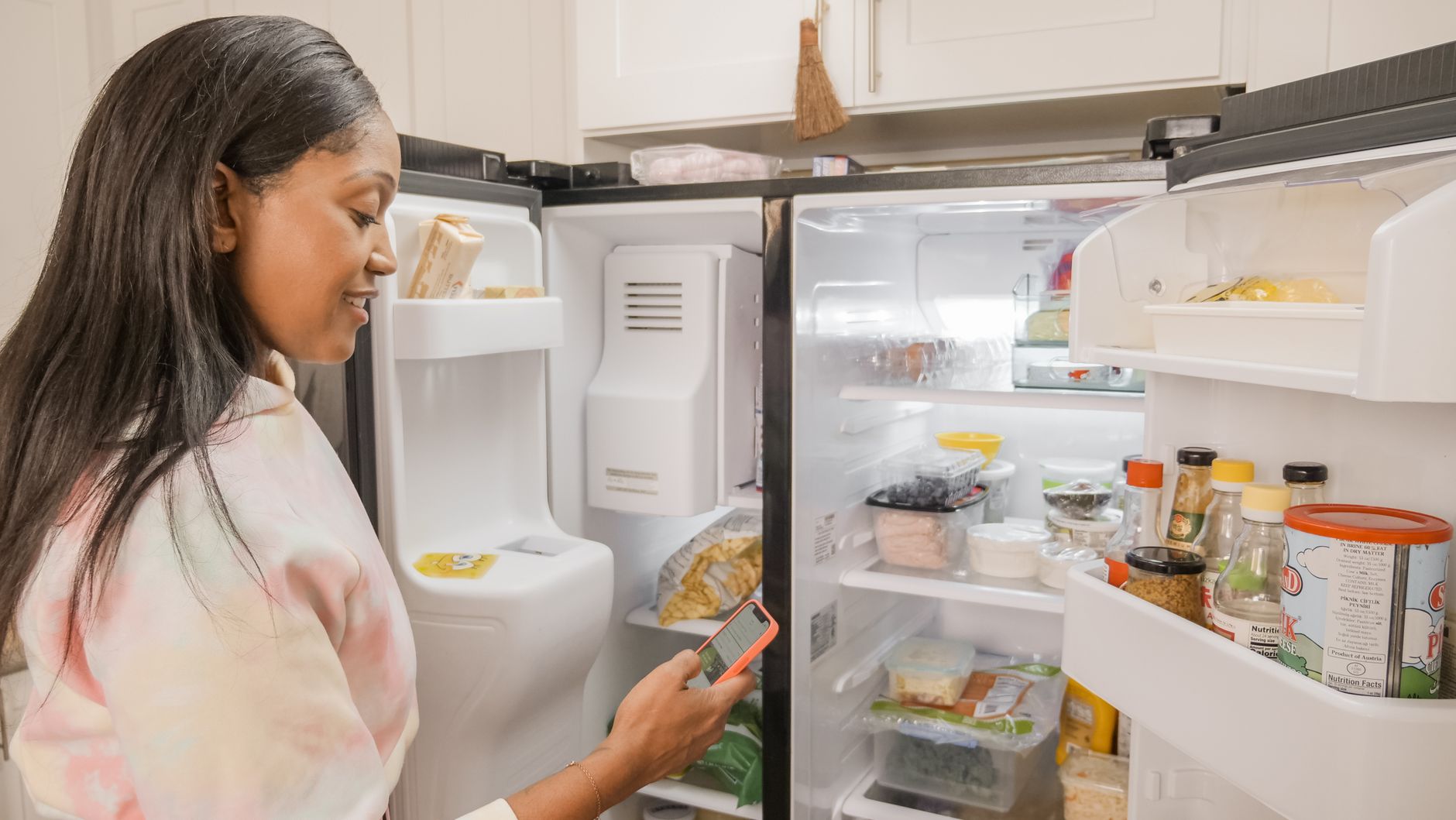 A woman at an open refrigerator