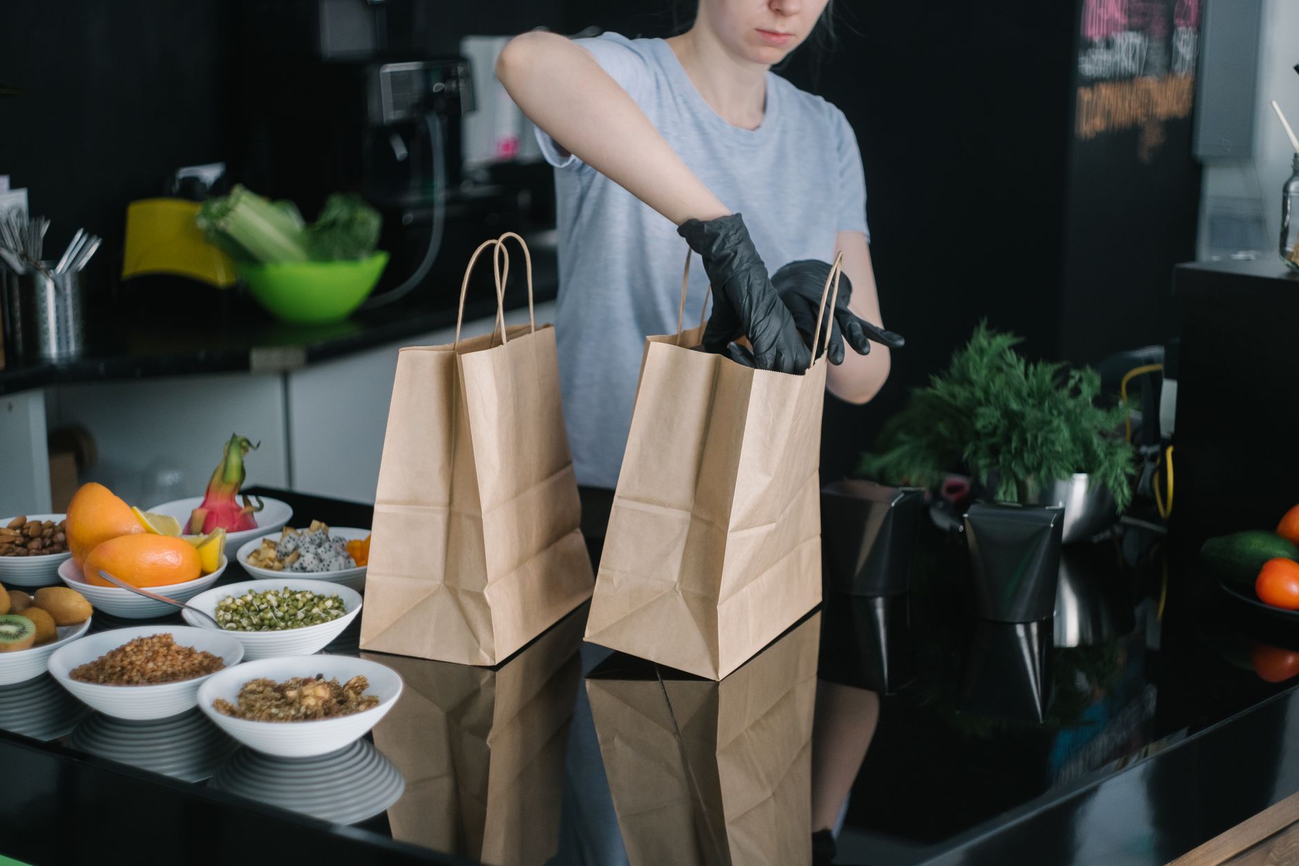 Packing groceries into paper bags in a kitchen