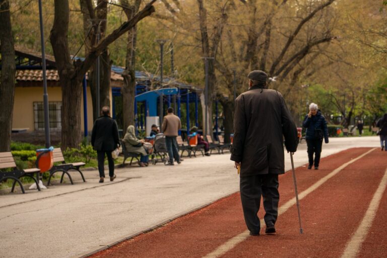 Best walking cane: an older adult walking with a cane in a park
