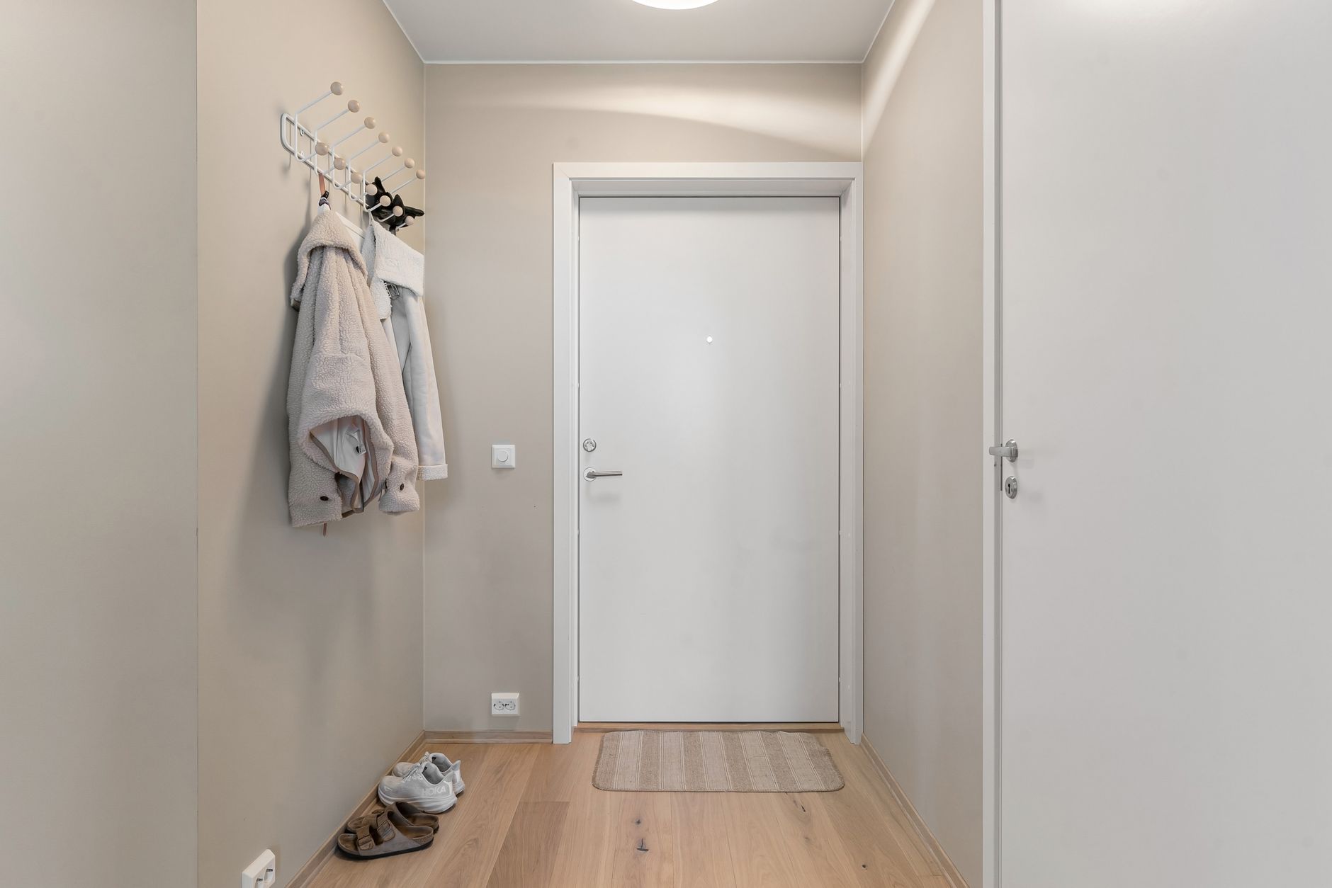 Jackets hanging on wall hooks in a hallway