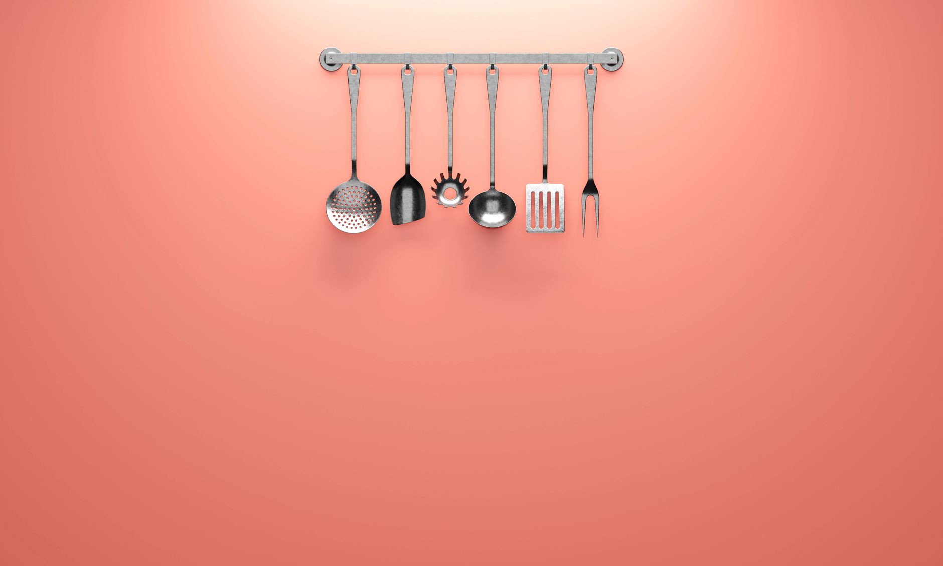 Kitchen utensils hanging from hooks on a wall