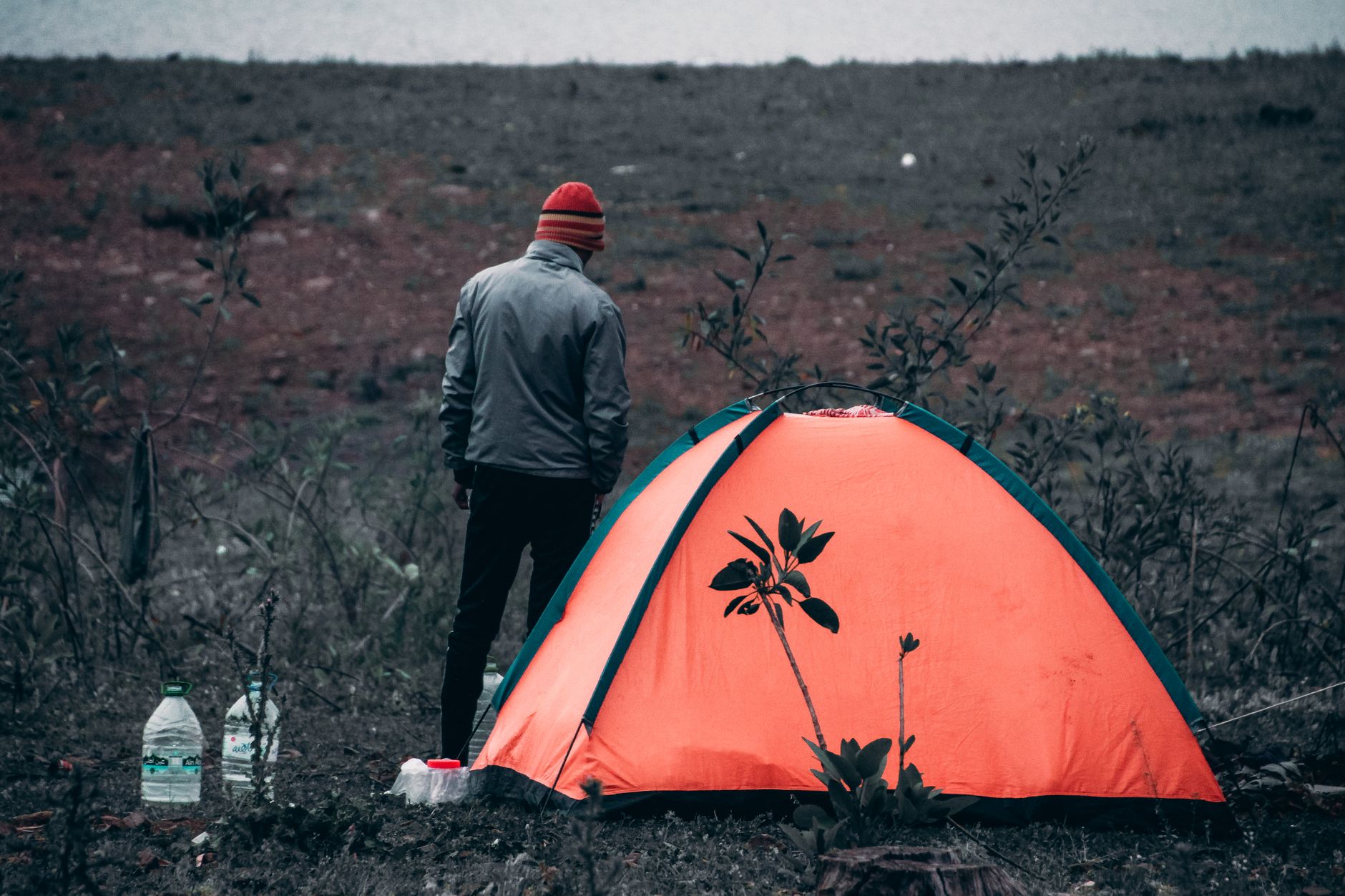 A person beside an orange tent with water bottles