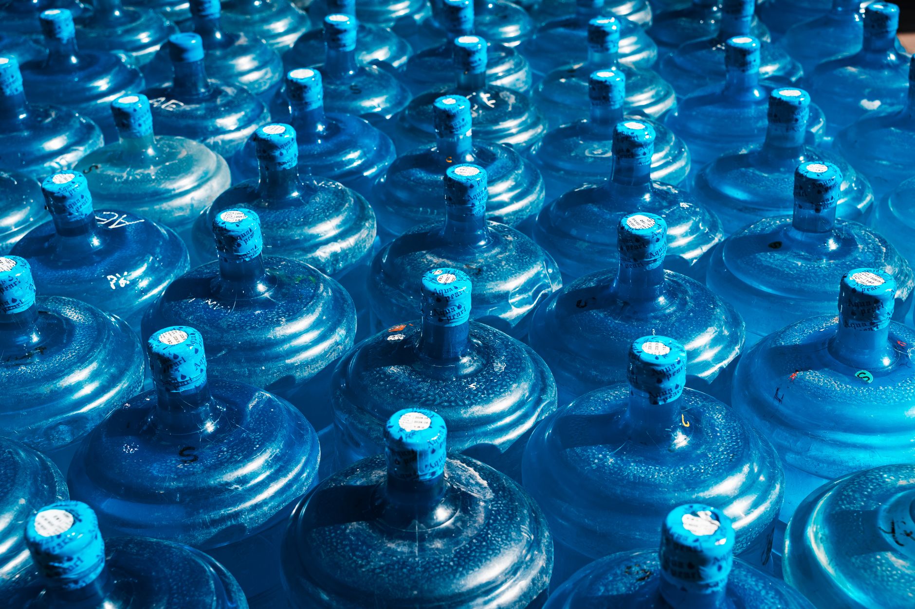 Rows of large blue water jugs