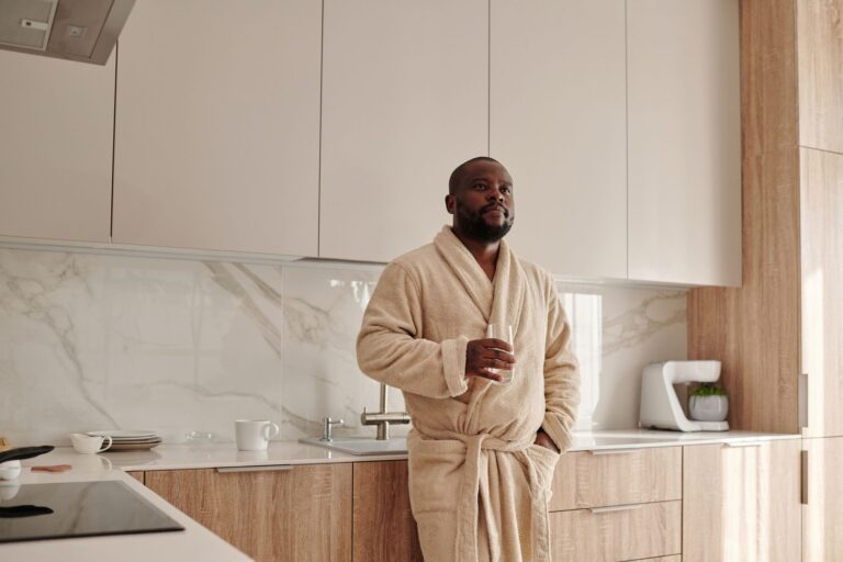 A man drinking water in a modern kitchen