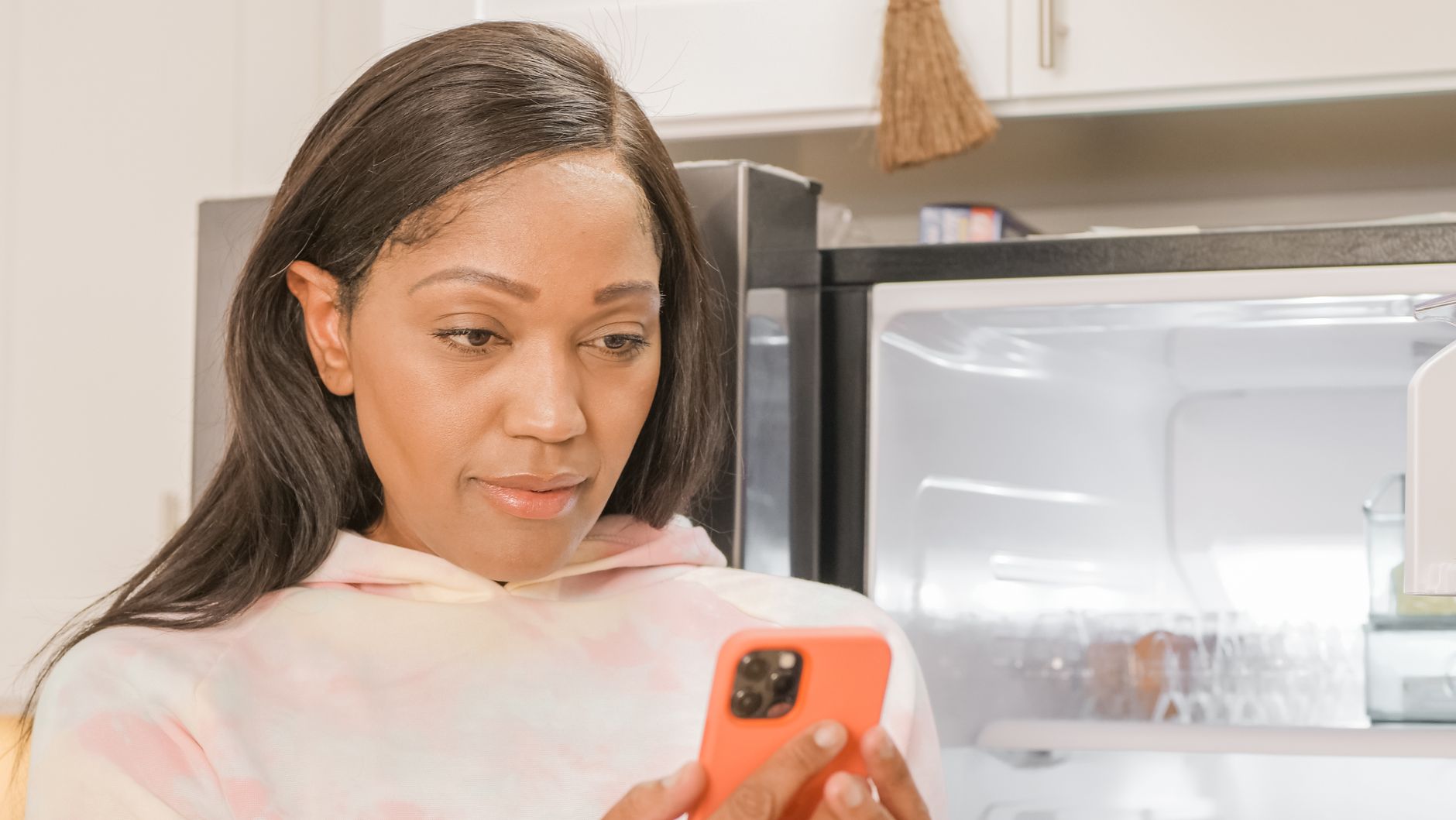 A woman checking her phone in the kitchen