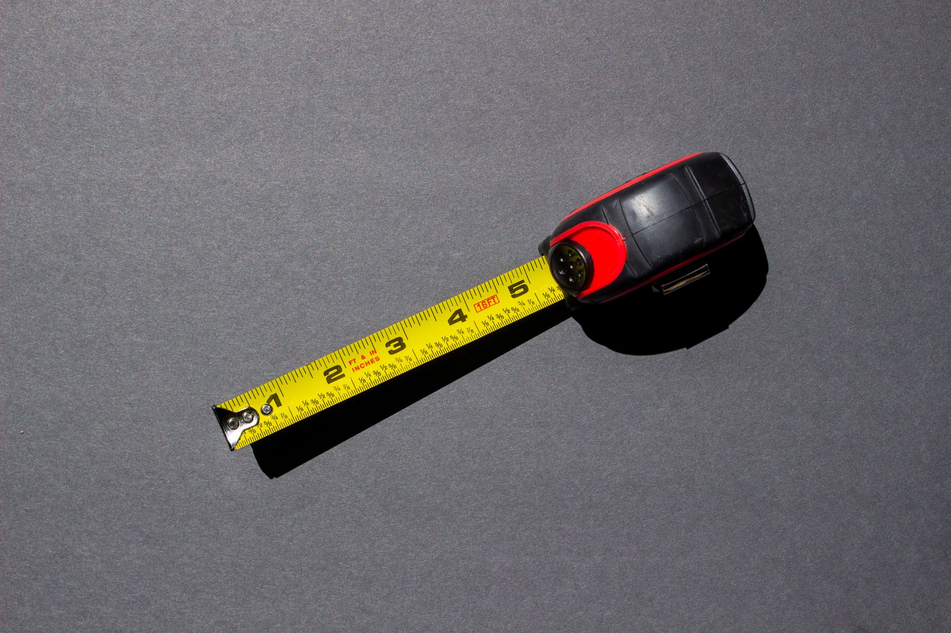 A tape measure on a gray surface