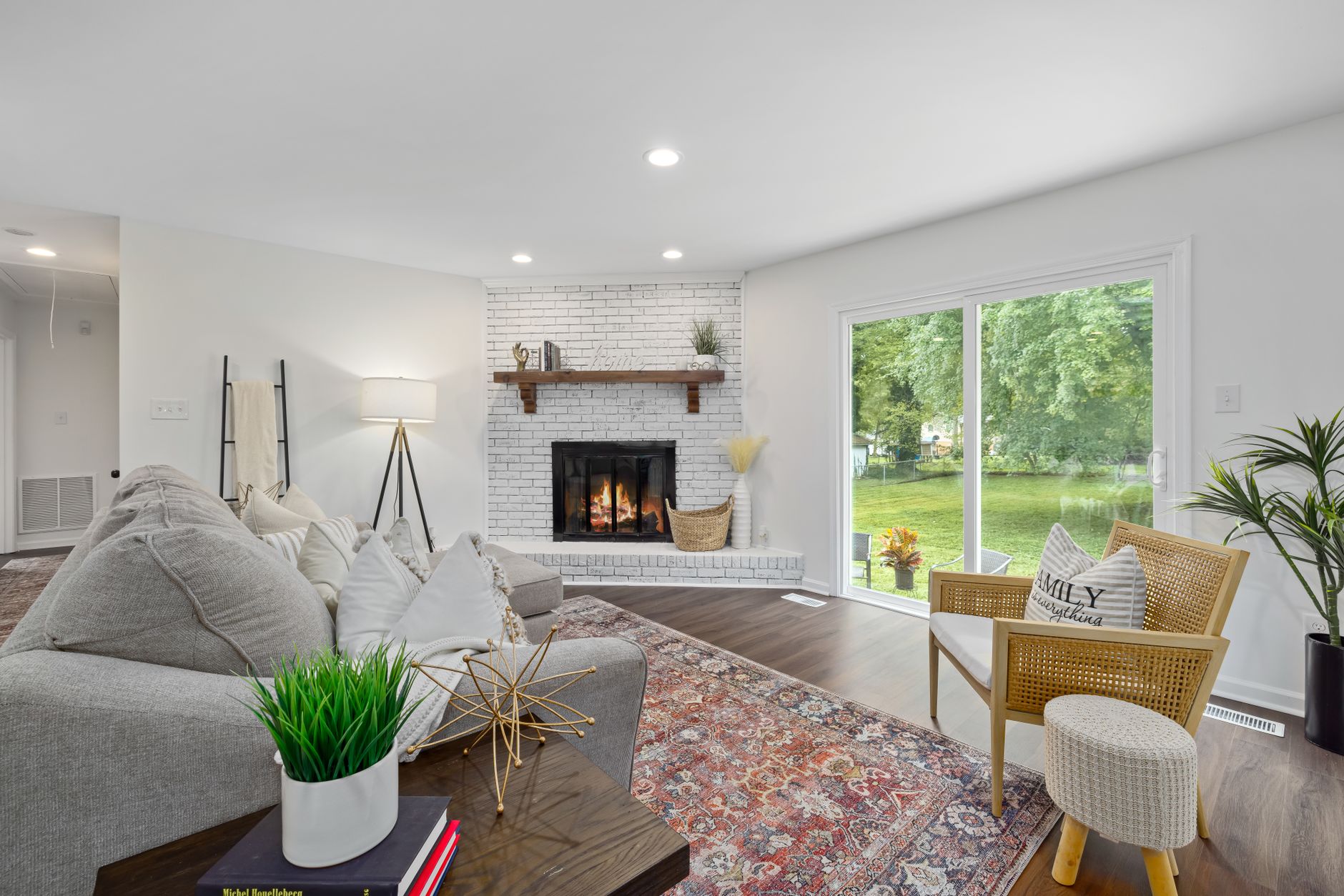 A living room with a brick fireplace and patio door