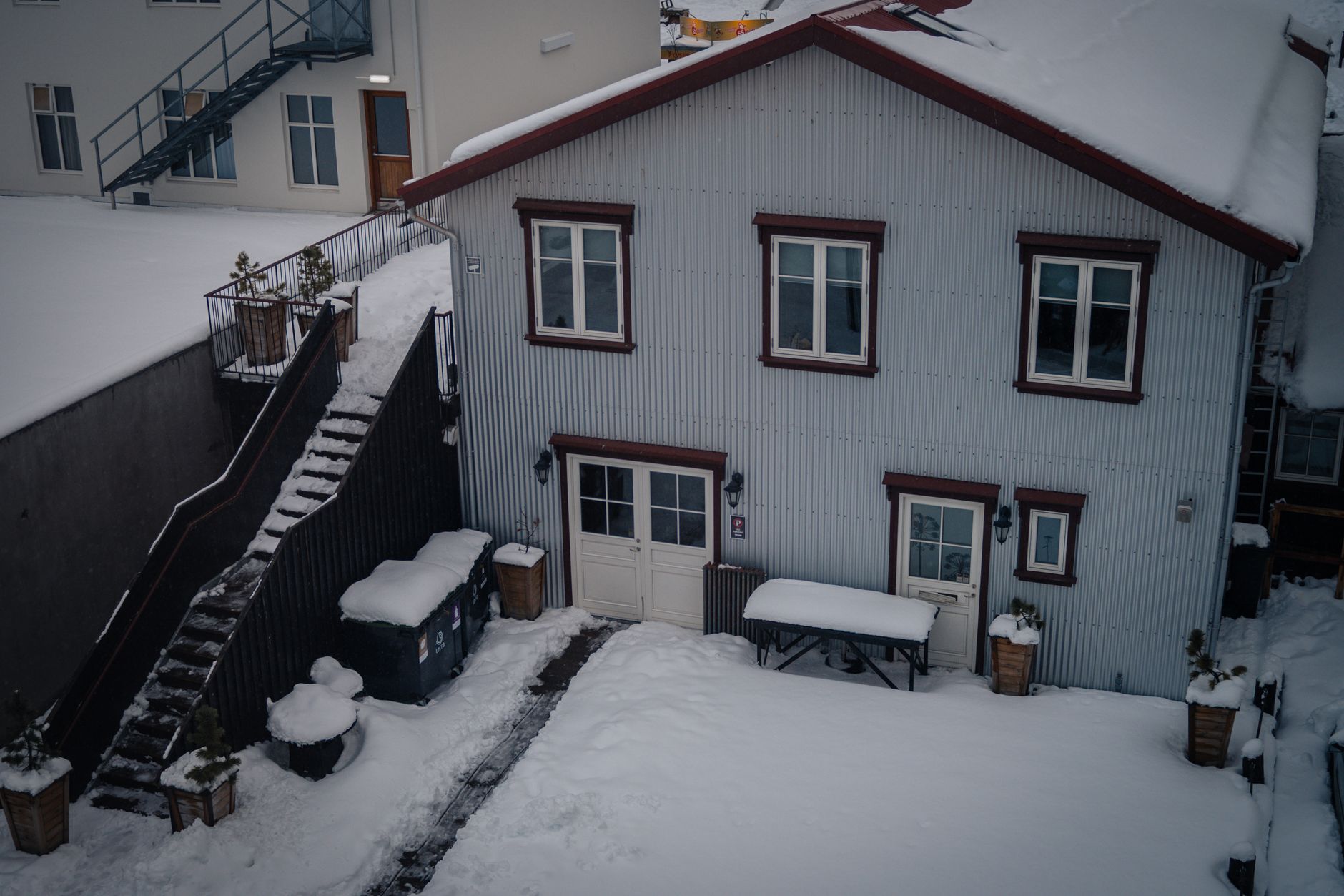 A snowy backyard behind a house