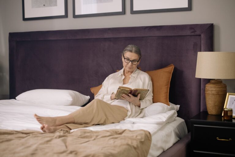 Best wedge pillow: a person reading while propped up on pillows in bed