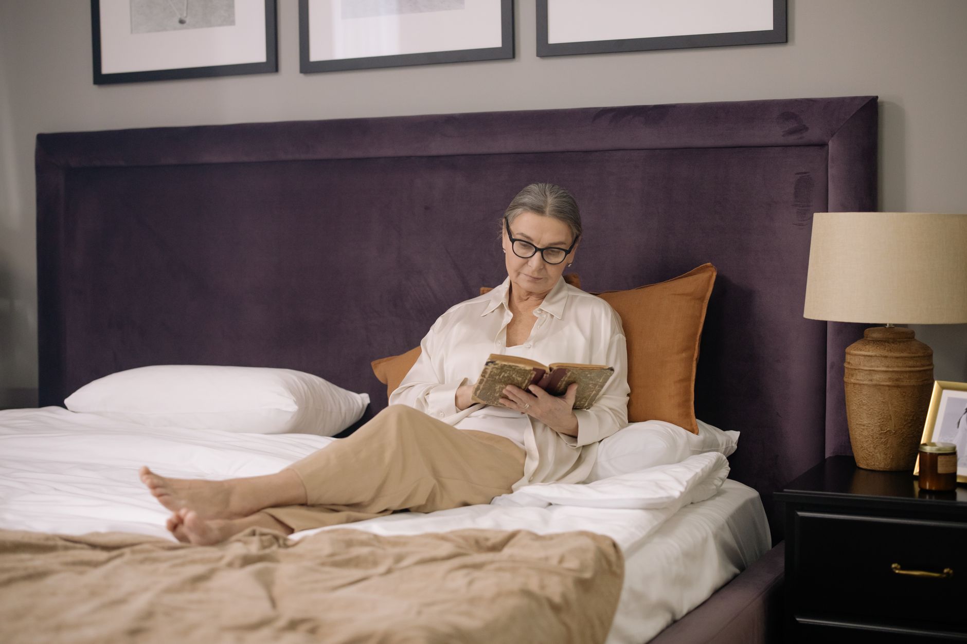 Best wedge pillow: a person reading while propped up on pillows in bed
