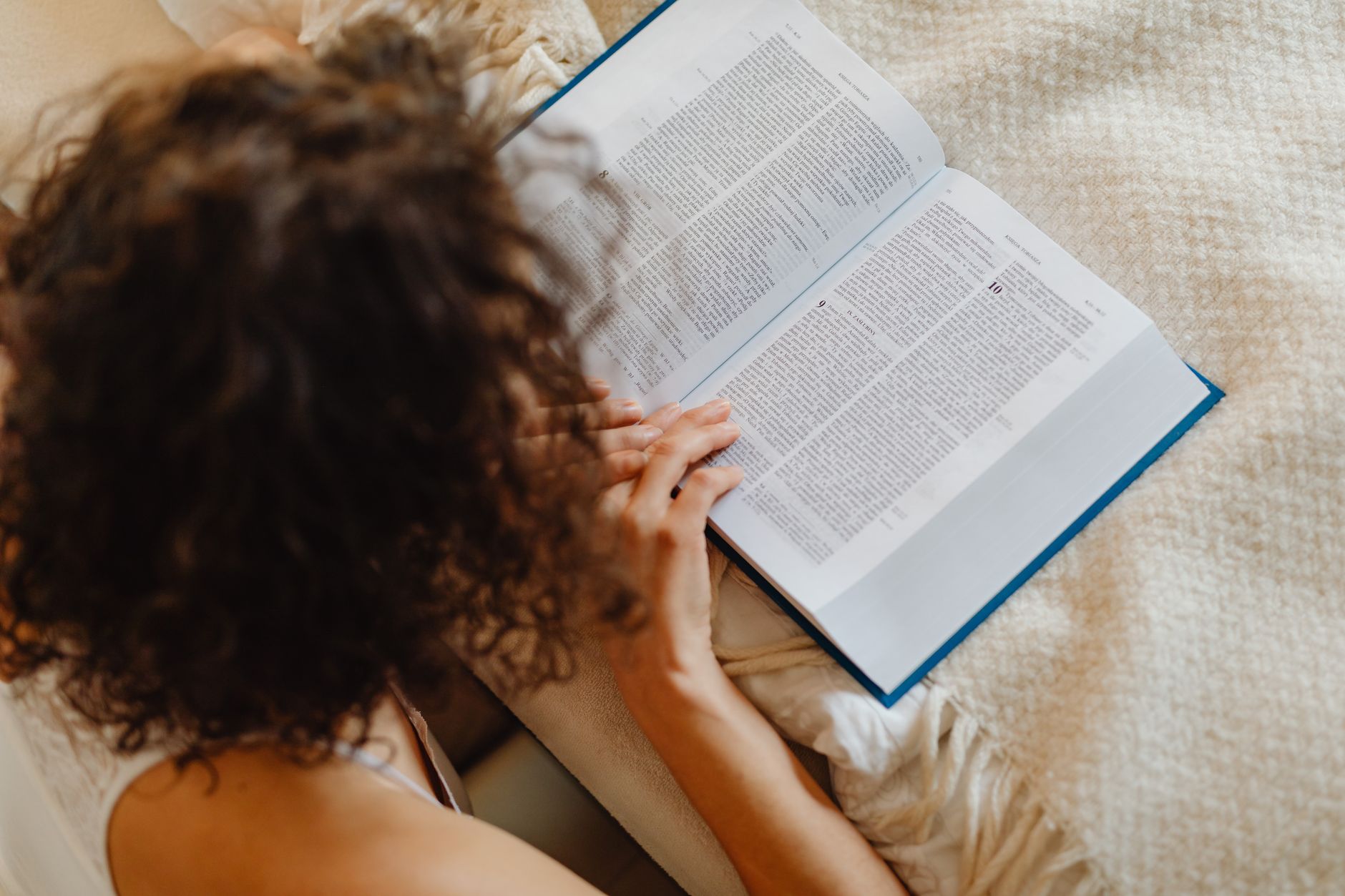 A woman reading a book in bed