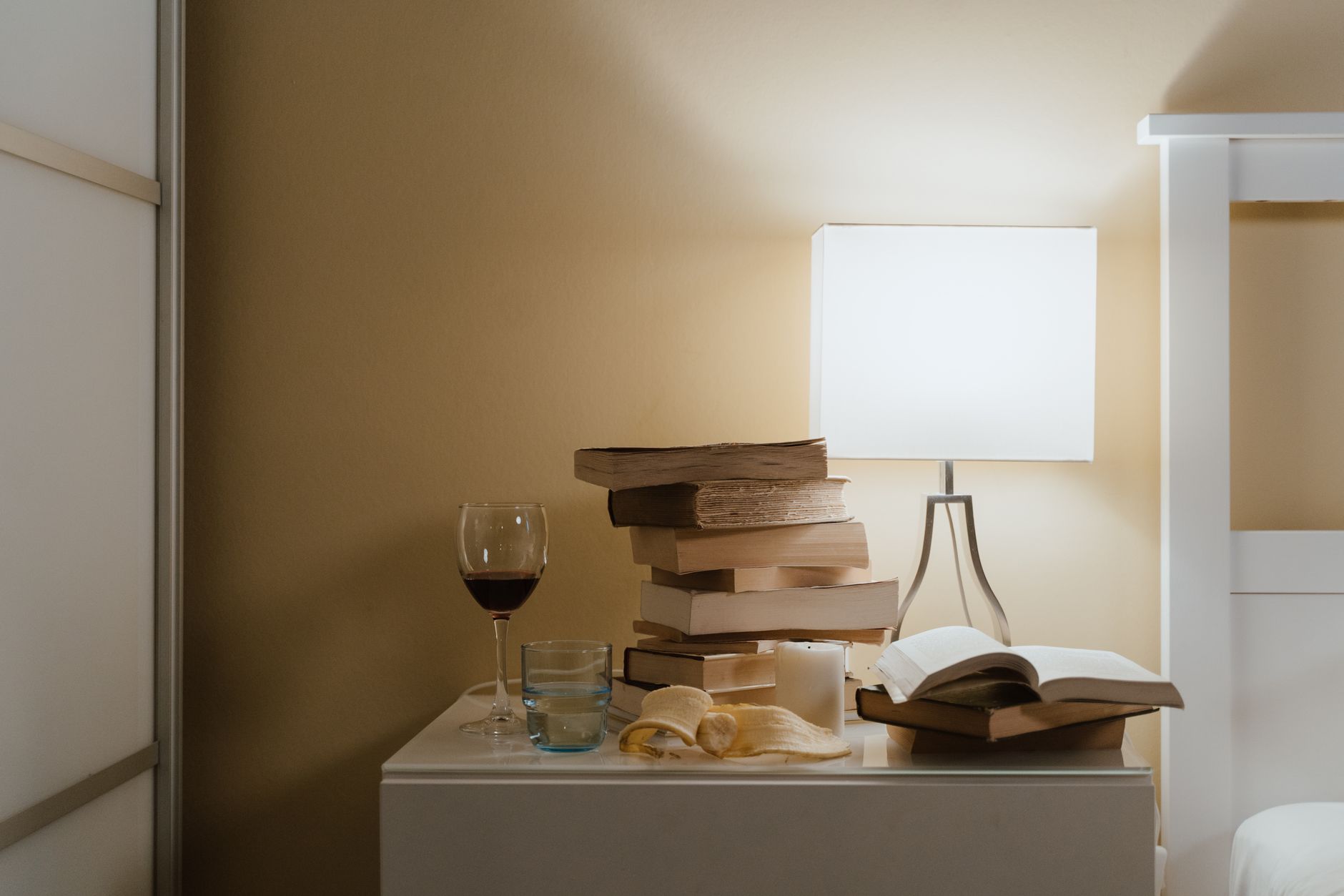 A lamp glowing on a bedside table at night