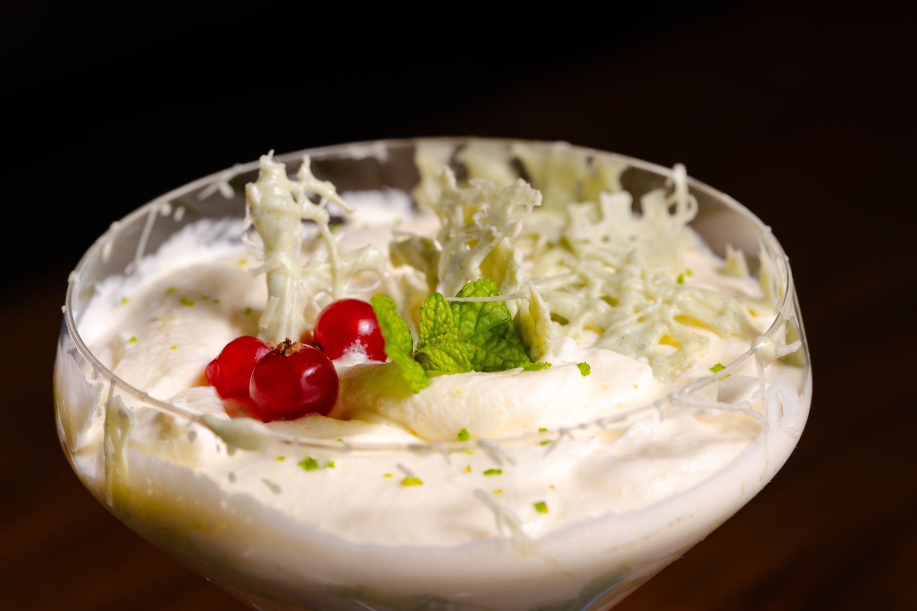A bowl of whipped cream topped with cherries