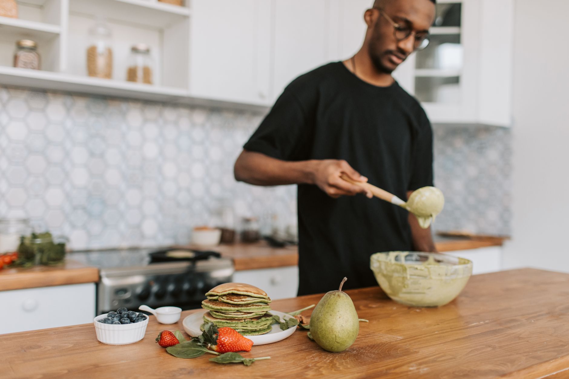 A man mixing batter at a kitchen counter