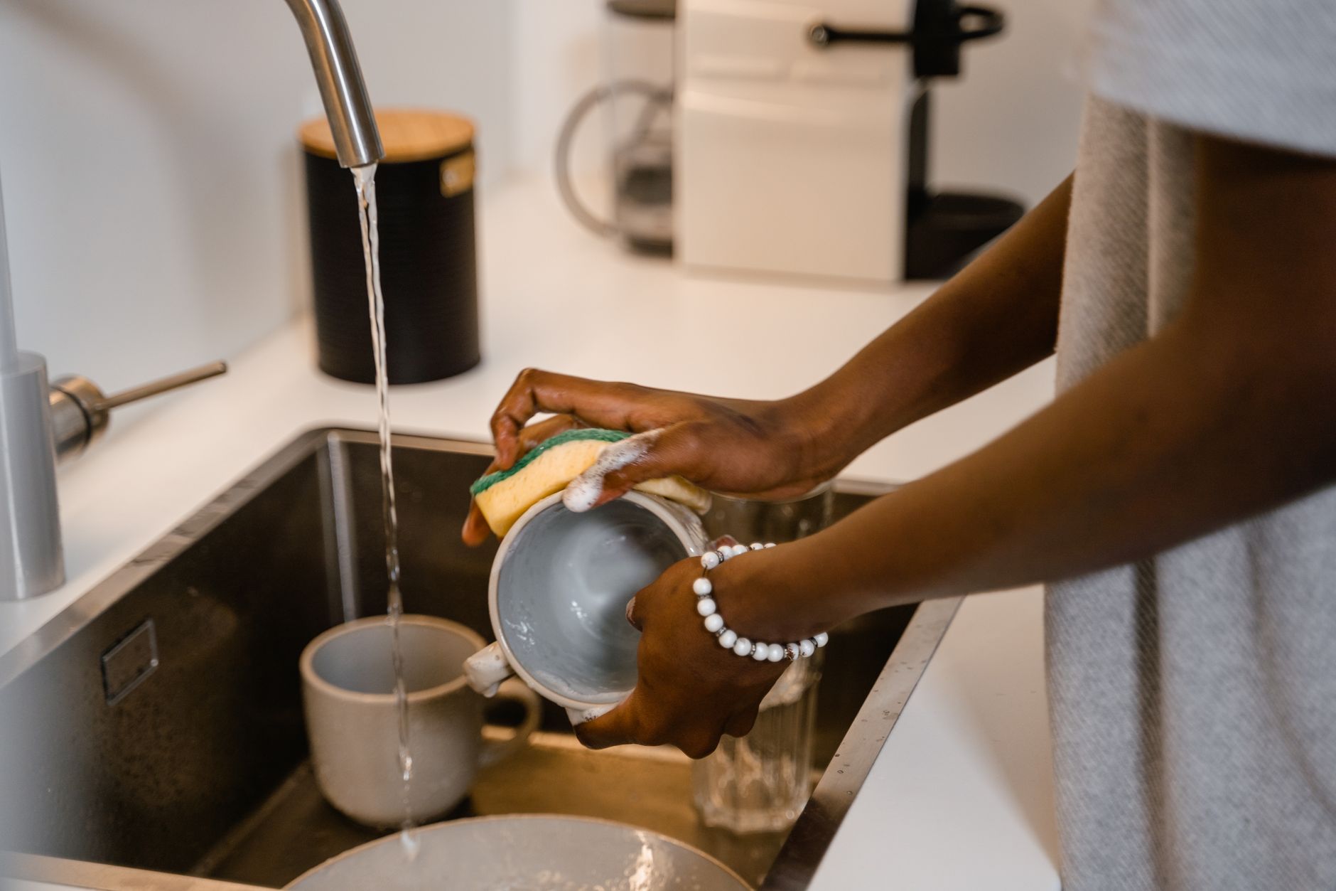 Washing a cup at a kitchen sink