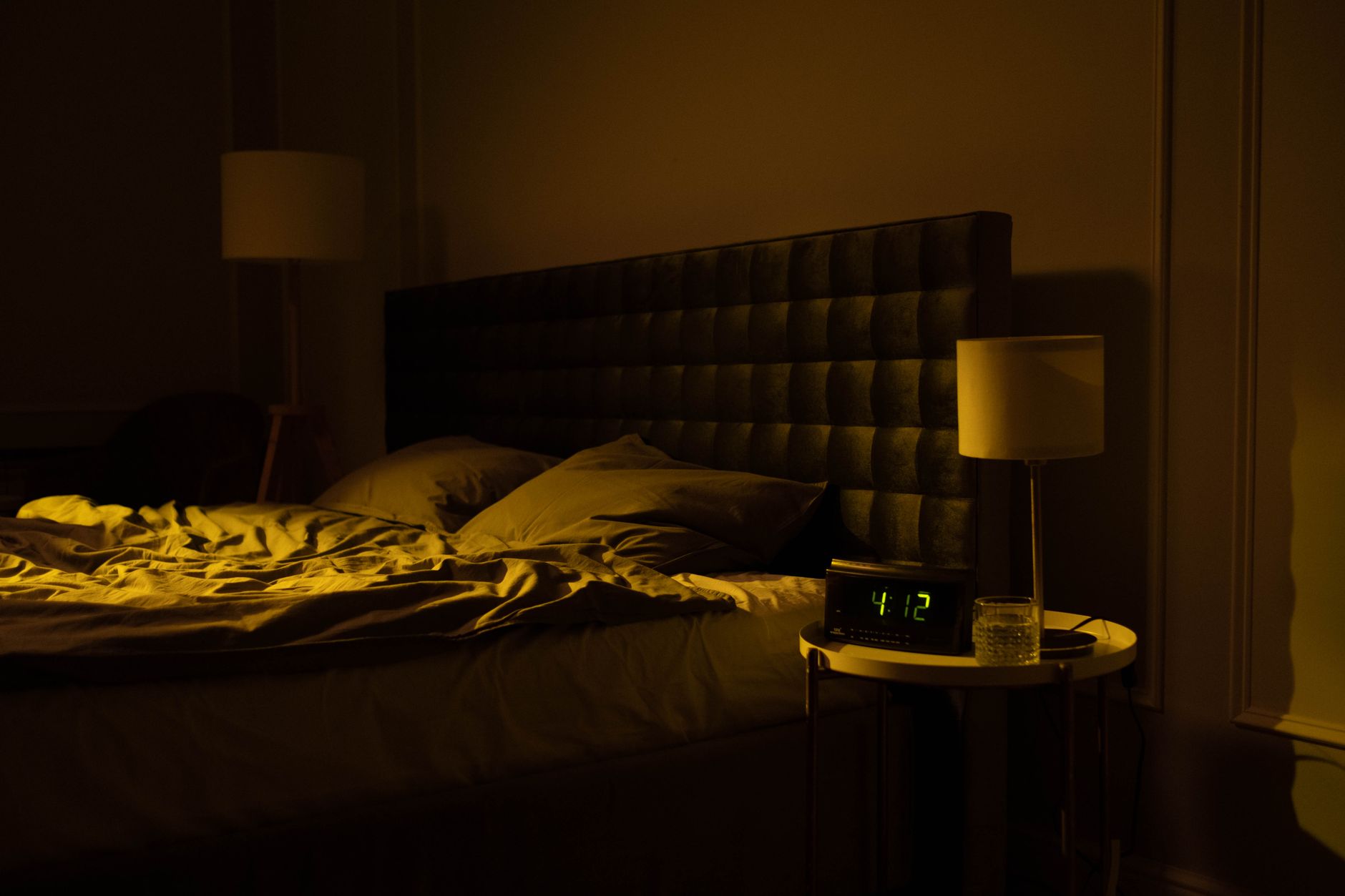 A digital clock on a nightstand at night
