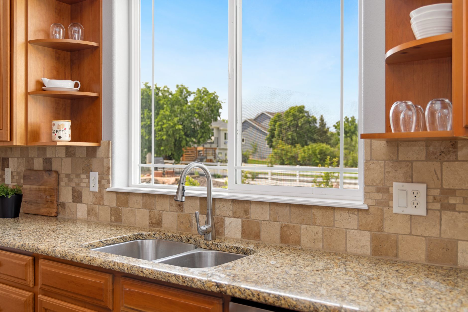 A kitchen sink below a large window