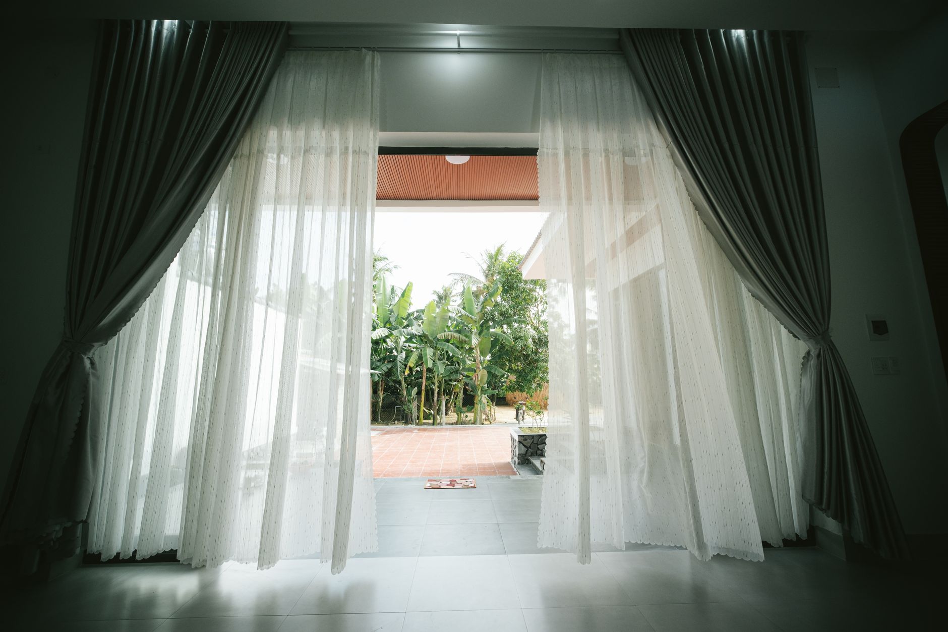 Sheer curtains framing an open doorway to a patio