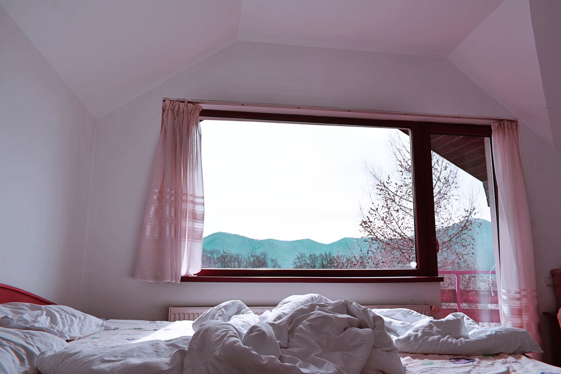 A bedroom window looking out on hills