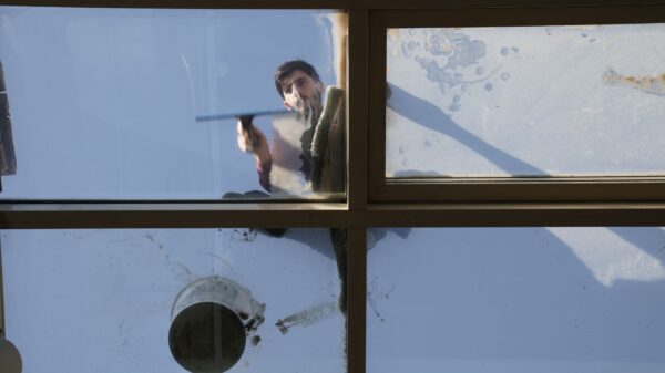 Best window vacuum: a man squeegeeing a large glass window