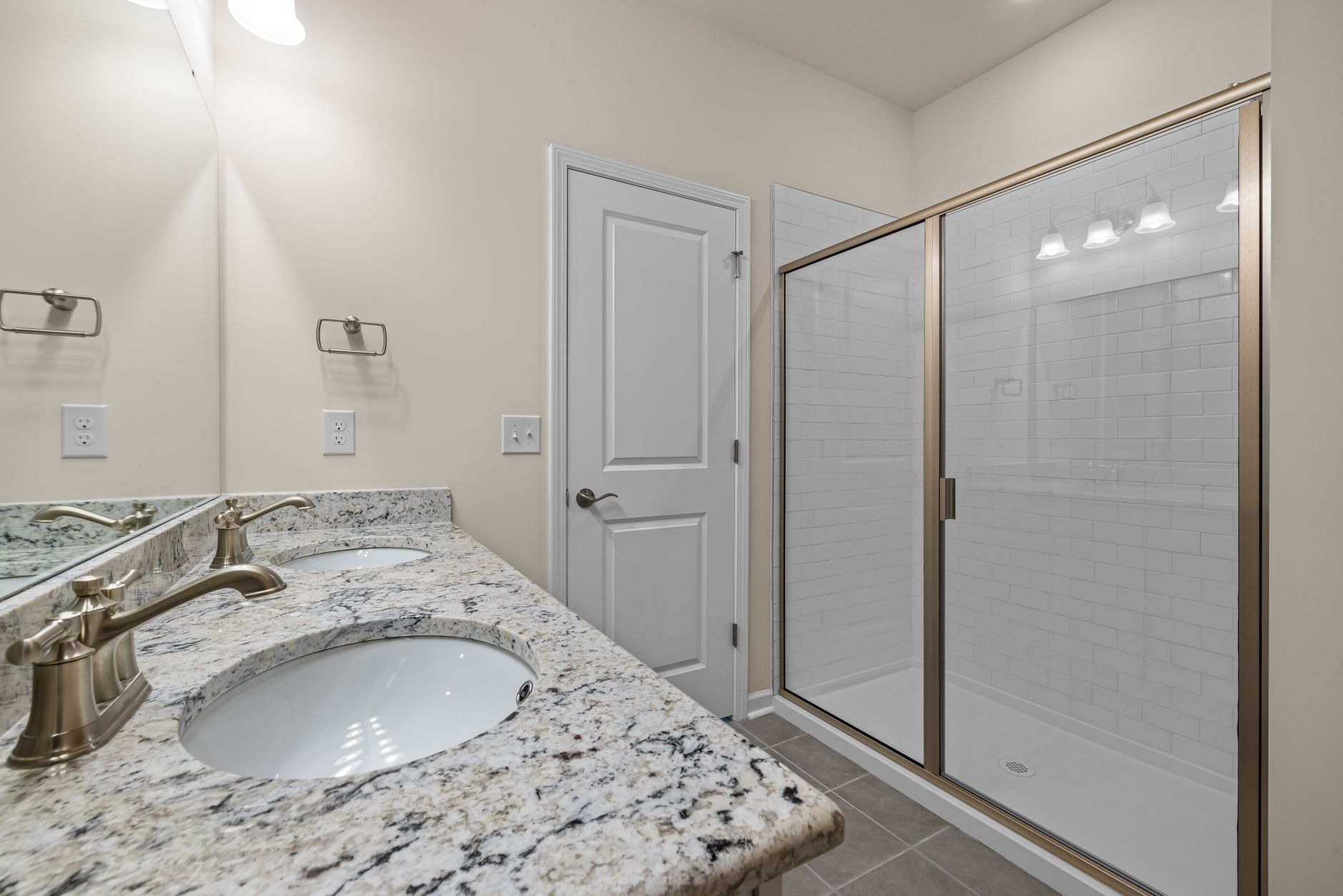 A bathroom vanity and glass shower door