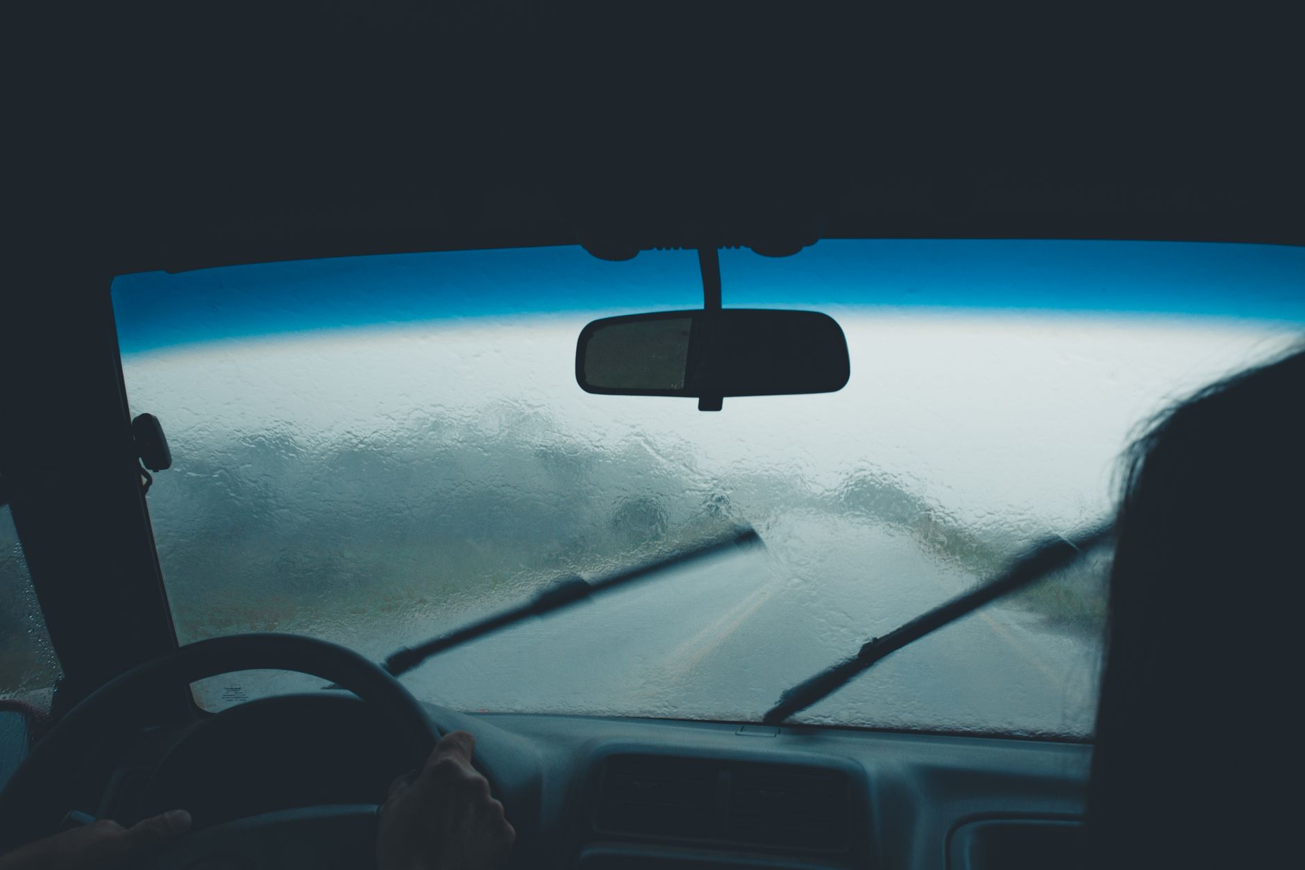 Best wiper blades: a windshield wiper clearing rain from a car windshield
