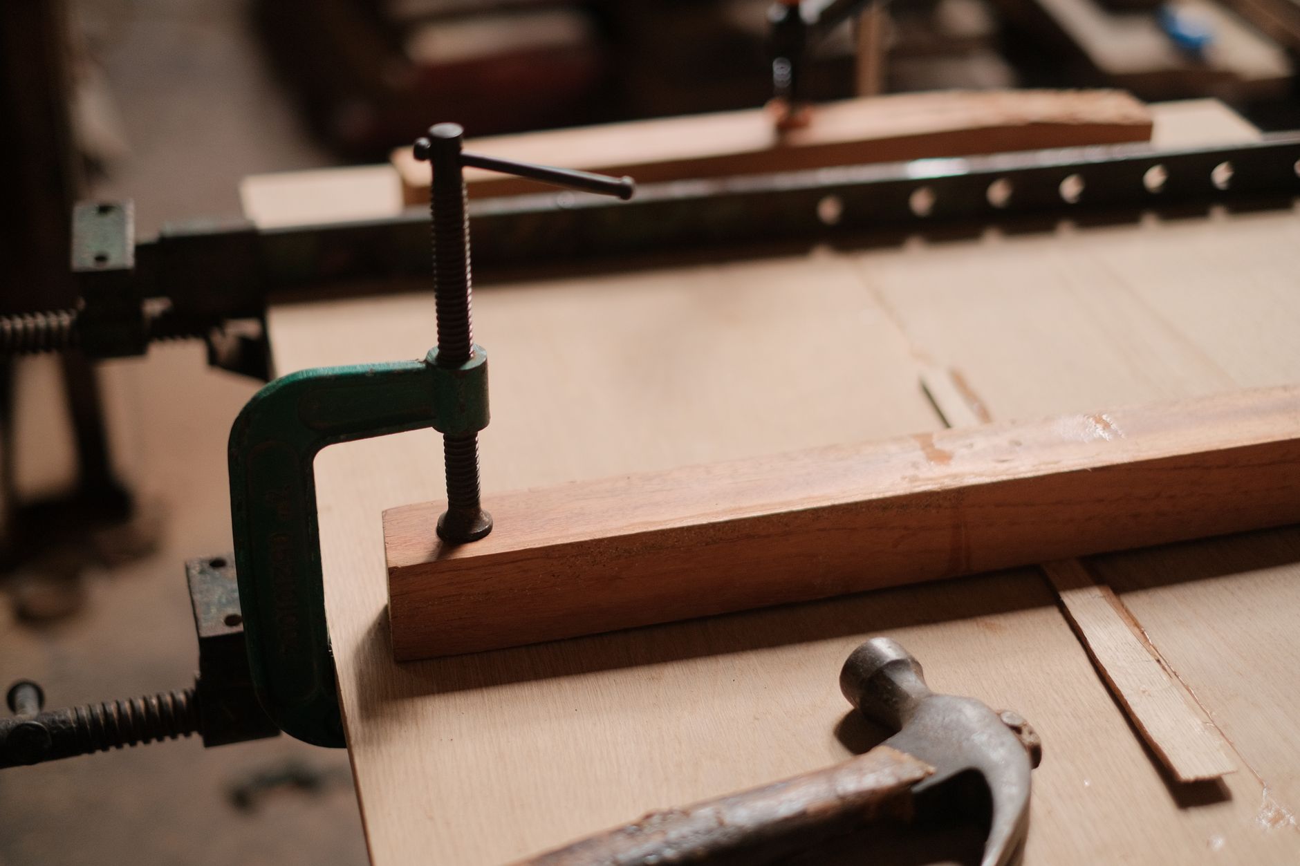 Clamps holding pieces of wood on a work surface